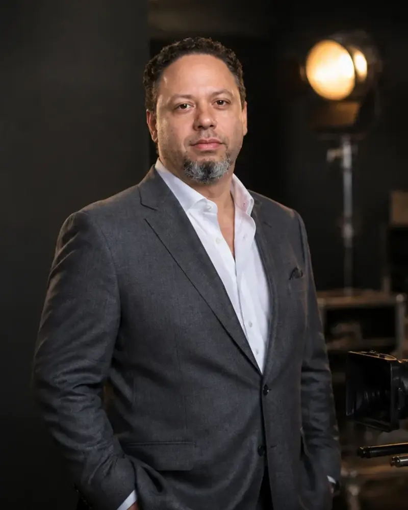 Tristan Desechenes in a tailored gray suit on a cinema soundstage